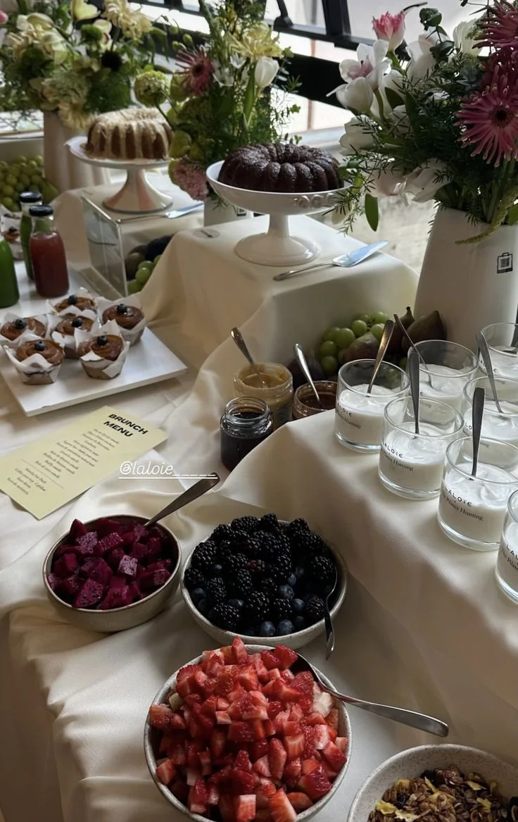 Mesa de brunch con flores, tortas y frutas, para el momento de conexión entre mujeres